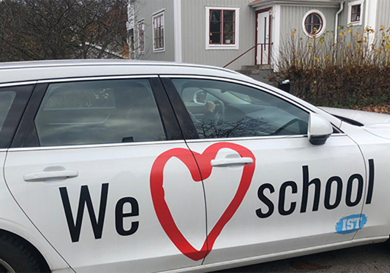 En närbild av sidan av en IST-bil. På ett stort klistermärke står "We heart school"
